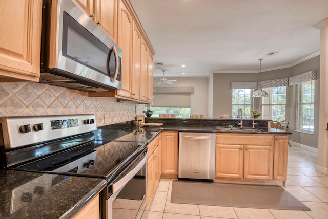 kitchen featuring appliances with stainless steel finishes, sink, decorative light fixtures, light tile patterned floors, and crown molding