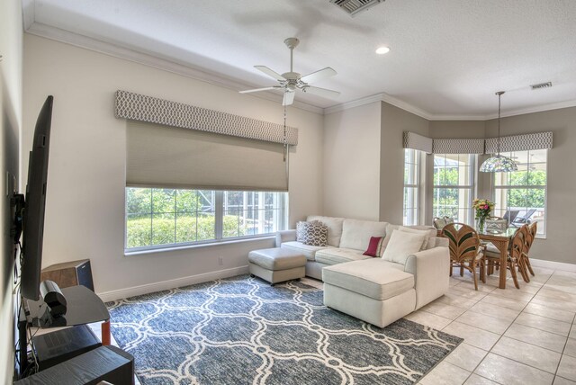 living room with crown molding, a textured ceiling, ceiling fan, and light tile patterned floors