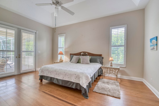 bedroom featuring light hardwood / wood-style flooring, access to outside, ceiling fan, and french doors