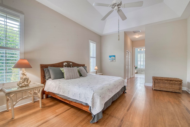 bedroom with ceiling fan, multiple windows, ensuite bathroom, and light hardwood / wood-style flooring