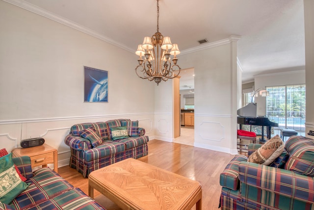 living room with ornamental molding, hardwood / wood-style flooring, and a notable chandelier