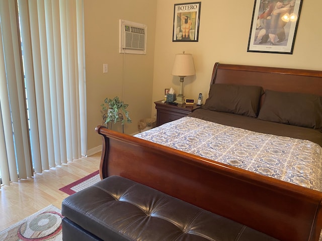 bedroom featuring a wall unit AC and light hardwood / wood-style floors