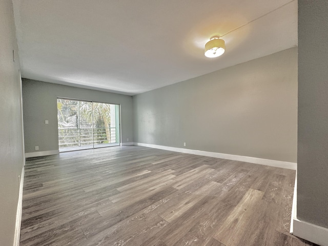 spare room featuring baseboards and wood finished floors