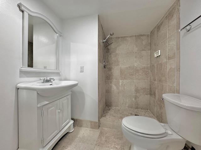 bathroom featuring tiled shower, tile patterned floors, toilet, and vanity