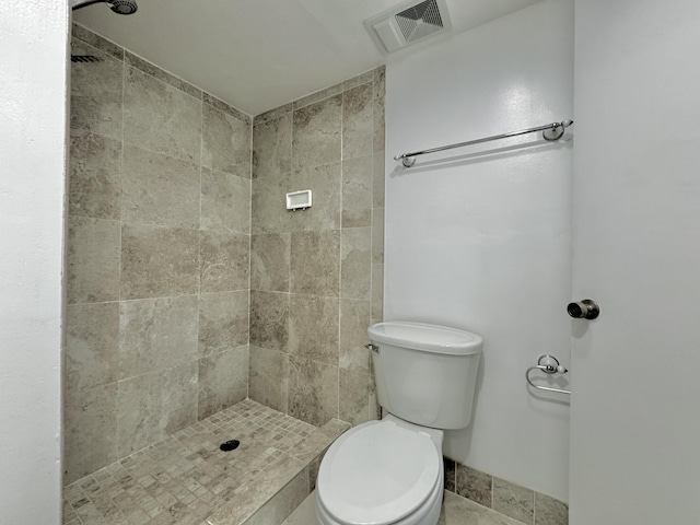 bathroom featuring toilet, a stall shower, and visible vents