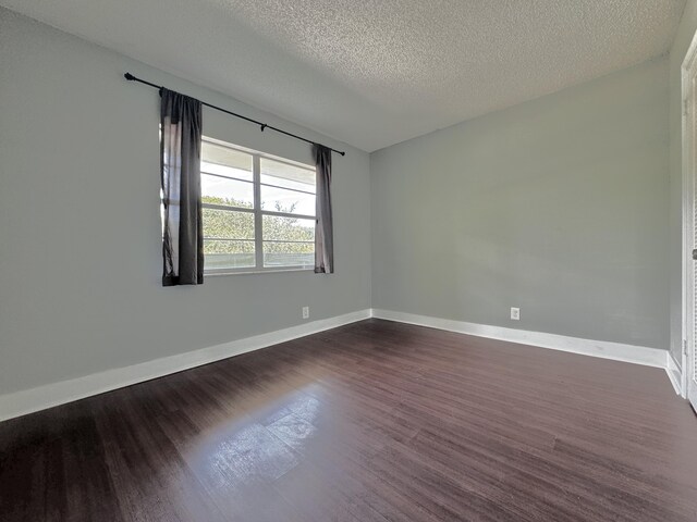 unfurnished room with a textured ceiling and wood-type flooring