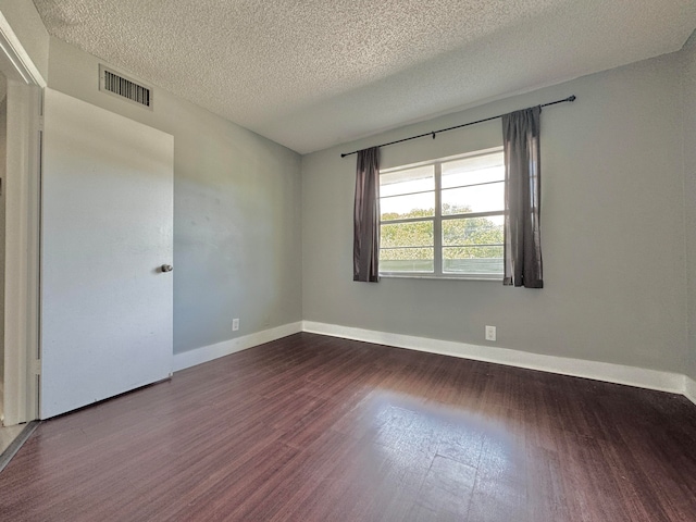 spare room with a textured ceiling and hardwood / wood-style floors