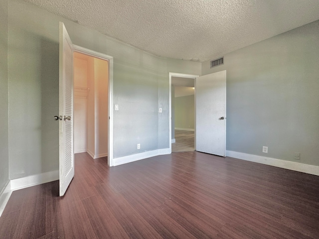 unfurnished bedroom featuring a textured ceiling, a closet, and hardwood / wood-style floors