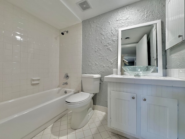 full bathroom featuring tile patterned flooring, toilet, vanity, and tiled shower / bath