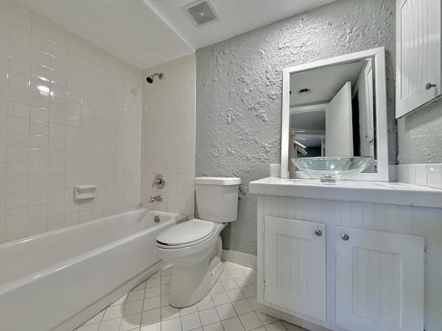 full bathroom with visible vents, bathing tub / shower combination, a textured wall, tile patterned flooring, and vanity