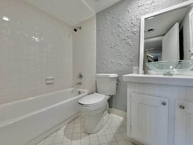 full bathroom featuring tiled shower / bath combo, vanity, tile patterned flooring, and toilet