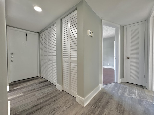 hall featuring light wood-style floors and baseboards