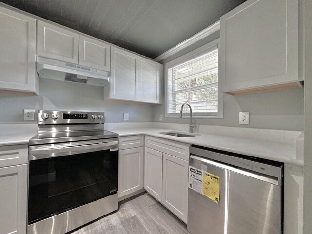 kitchen featuring sink, appliances with stainless steel finishes, white cabinets, and light wood-type flooring