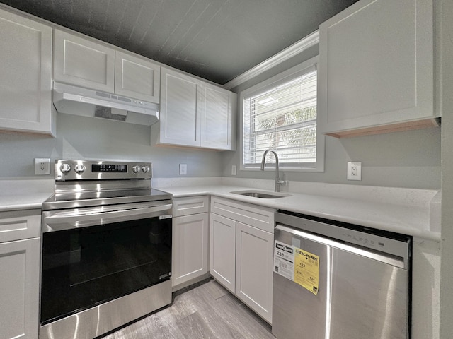 kitchen featuring light countertops, stainless steel range with electric cooktop, white cabinetry, dishwasher, and under cabinet range hood