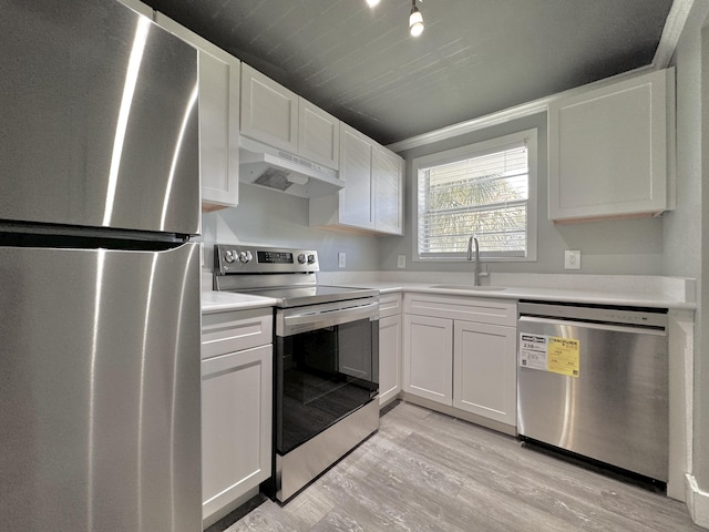 kitchen featuring under cabinet range hood, stainless steel appliances, a sink, white cabinetry, and light countertops