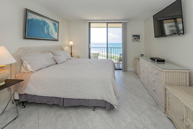 tiled bedroom with access to outside, a textured ceiling, and floor to ceiling windows