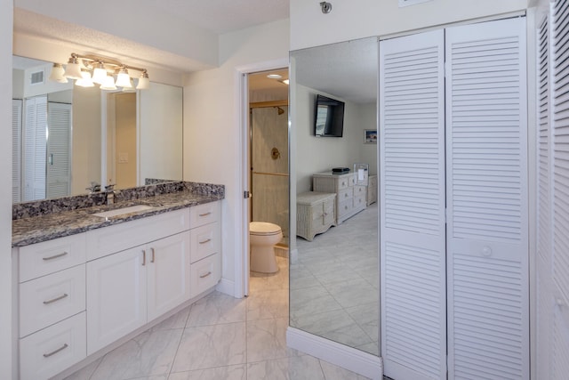 bathroom featuring vanity, toilet, and tile patterned flooring