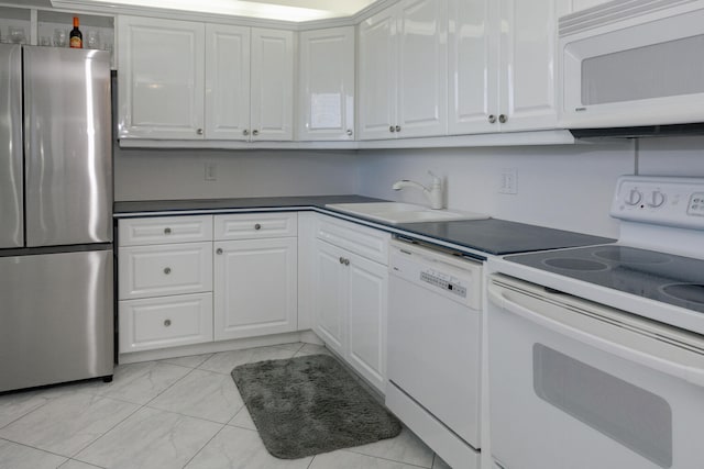 kitchen with light tile patterned flooring, sink, white cabinetry, and white appliances