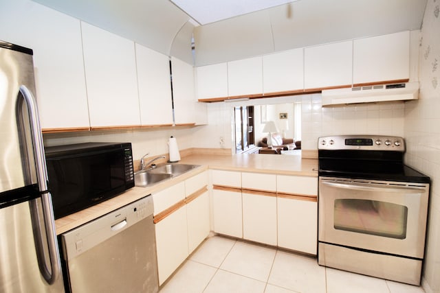 kitchen with light tile patterned flooring, white cabinetry, stainless steel appliances, and sink