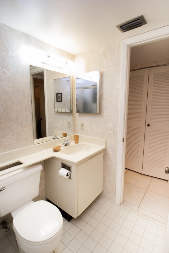 bathroom with vanity, toilet, and tile patterned flooring