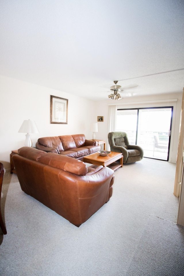 carpeted living room with ceiling fan