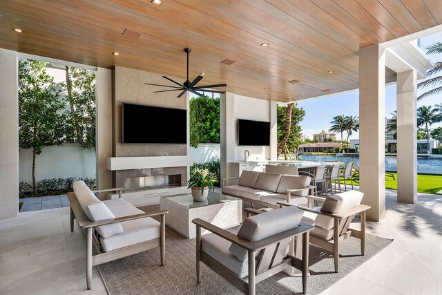 view of patio featuring an outdoor living space with a fireplace and ceiling fan