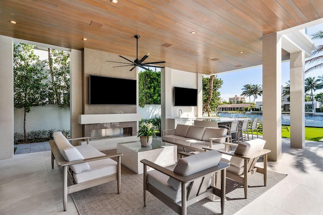 view of patio / terrace featuring an outdoor living space with a fireplace, a swimming pool, and ceiling fan