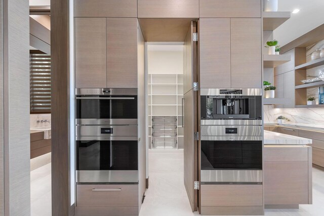 kitchen featuring light tile patterned floors, light brown cabinetry, and double oven