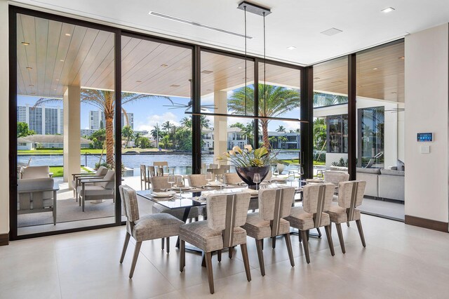 dining room featuring floor to ceiling windows, plenty of natural light, and a water view