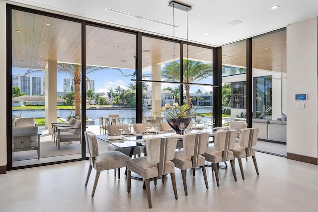 dining space featuring a water view and a wall of windows