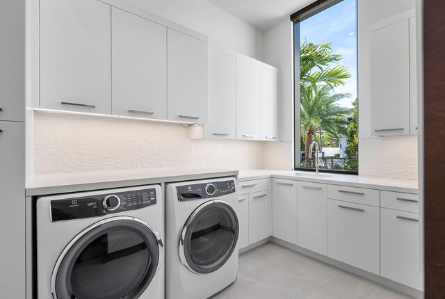 laundry room with washer and dryer, sink, cabinets, and plenty of natural light