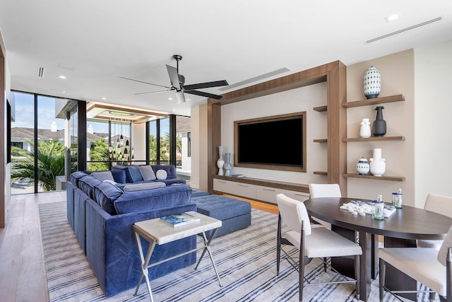 living room with a healthy amount of sunlight, floor to ceiling windows, and light hardwood / wood-style flooring