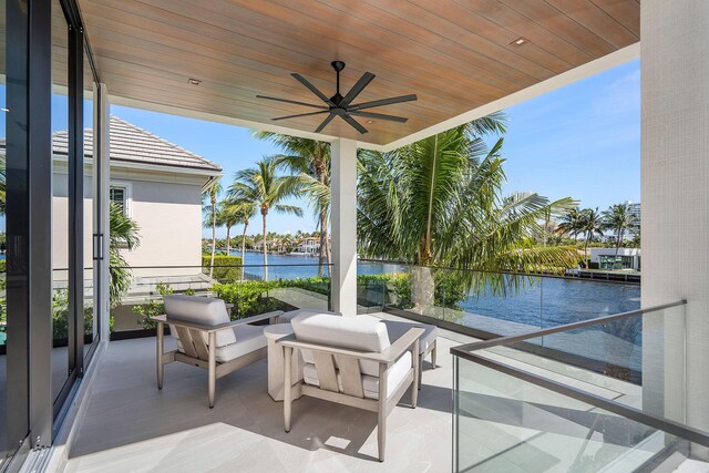 view of patio featuring ceiling fan, a water view, and a balcony