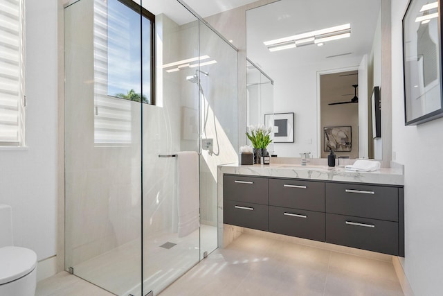 bathroom with tile patterned flooring, a shower with door, vanity, and toilet