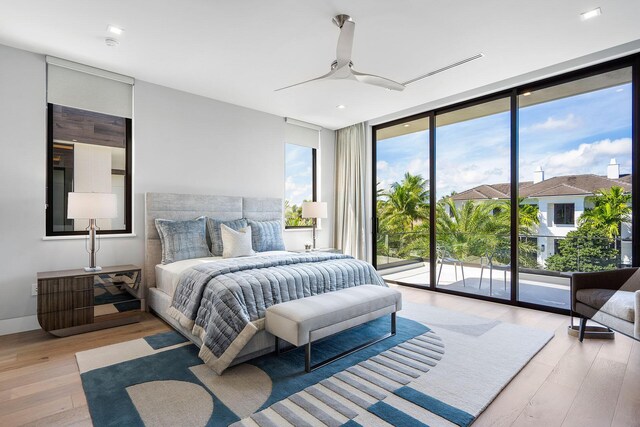 bedroom featuring ceiling fan, a wall of windows, access to outside, and light hardwood / wood-style flooring