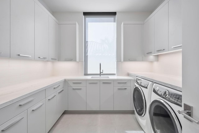 laundry area featuring cabinets, washer and dryer, and sink