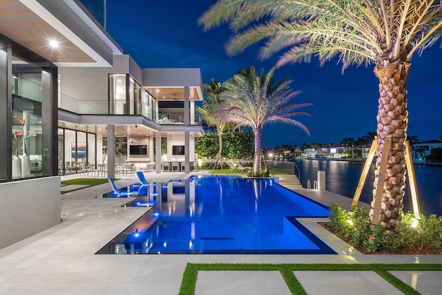 pool at twilight featuring a patio and a water view