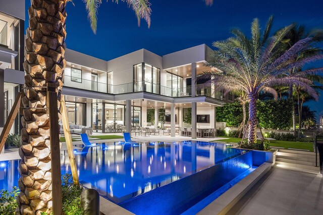 pool at twilight featuring a patio area