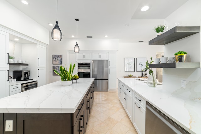 kitchen with stainless steel appliances, light stone counters, white cabinets, and wine cooler