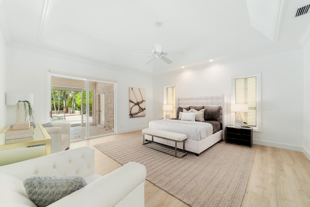 bedroom with light hardwood / wood-style flooring, access to exterior, ceiling fan, a raised ceiling, and ornamental molding