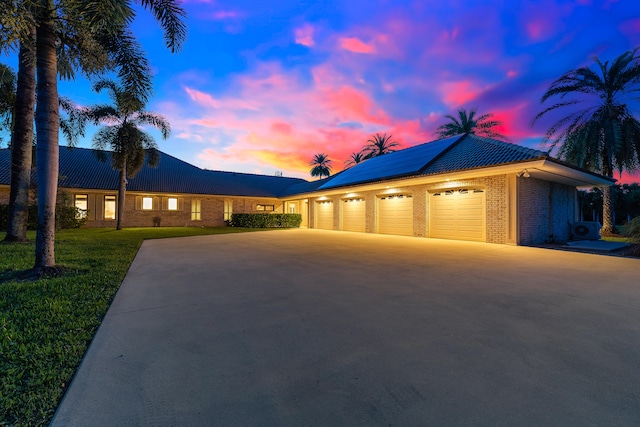 ranch-style house with a garage and a lawn