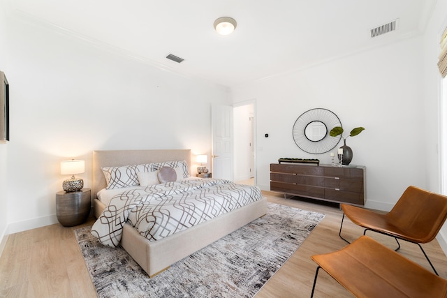 bedroom featuring light hardwood / wood-style floors and crown molding