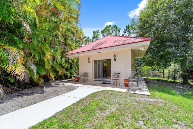 back of property with a yard and a patio