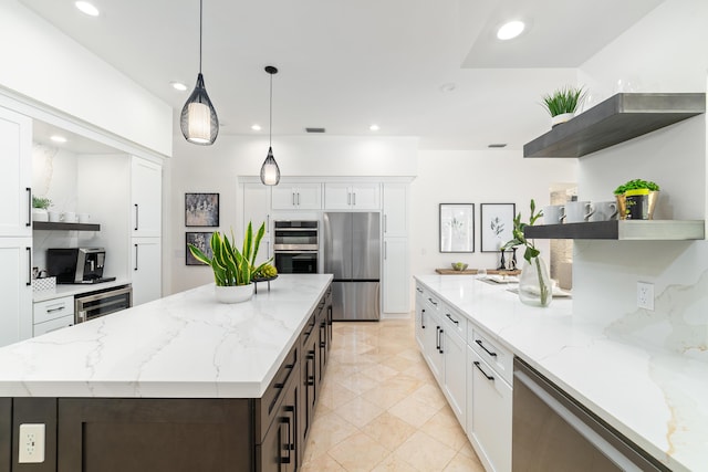 kitchen featuring stainless steel appliances, white cabinetry, and pendant lighting