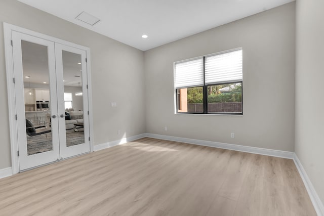 unfurnished room featuring light hardwood / wood-style floors and french doors