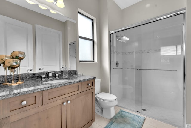 bathroom with vanity, a shower with shower door, toilet, and tile patterned floors