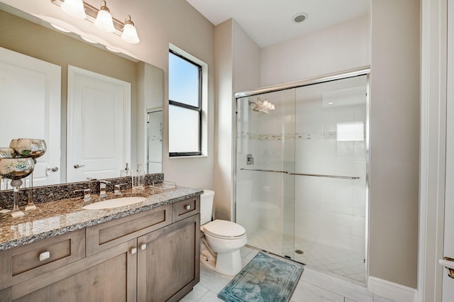 bathroom featuring walk in shower, vanity, tile patterned flooring, and toilet