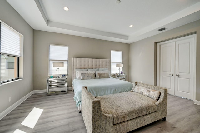 bedroom with multiple windows and light hardwood / wood-style floors