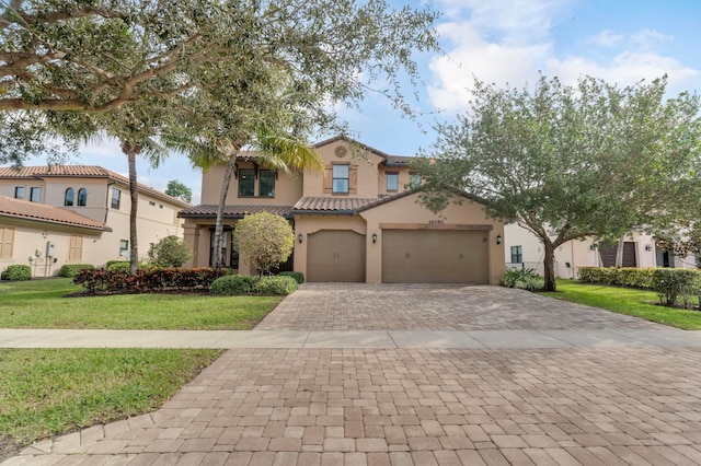 mediterranean / spanish house with a garage and a front lawn