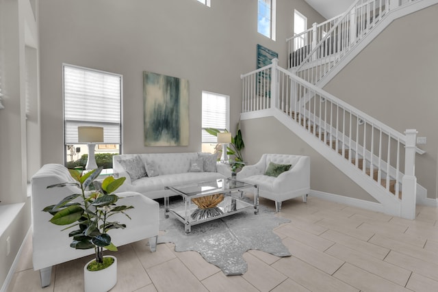 living room featuring a towering ceiling and a healthy amount of sunlight